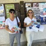 Anna Kuznecovienė ir Indrė Kižienė prie skelbimų lentos